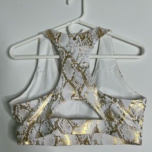 Fabletics sat with sports bra and leggings. Gold foil, snake, print